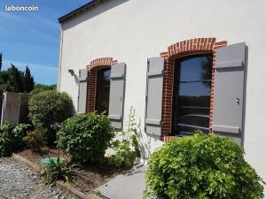 a white house with two windows and bushes at Ty Yé in Sarzeau +5 photos