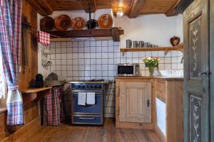 eine Küche mit einem blauen Herd und einer Mikrowelle in der Unterkunft ANNO 1698 Gîtes et Chambres d'Hôtes in Beblenheim
