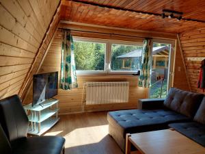 Chata na Orave so saunou a kúpacou kaďou في ناميستوفو: غرفة معيشة مع أريكة ونافذة كبيرة