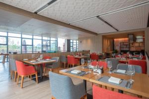 a restaurant with wooden tables and red chairs at Holiday Inn Resort Guiyang Qingyan, an IHG Hotel in Guiyang