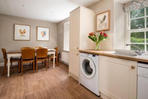 a kitchen and dining room with a washing machine and a table at Crailing Cottage in Jedburgh