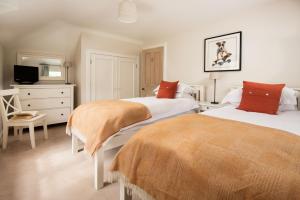 1 Schlafzimmer mit 2 Betten, einem TV und einer Kommode in der Unterkunft Crailing Cottage in Jedburgh