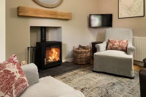 a living room with a fireplace and a chair at Crailing West Lodge in Jedburgh