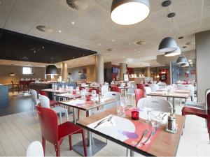 a restaurant with tables, chairs, and tables in it at Campanile Lille Euralille in Lille