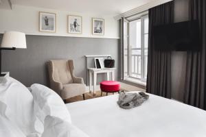 une chambre d'hôtel avec un lit et une chaise dans l'établissement Grand Hôtel Perros-Guirec, à Perros-Guirec