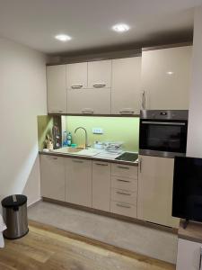 a kitchen with white cabinets and a microwave at Apartmani Twins Zlatibor in Zlatibor