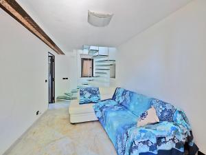 ein Wohnzimmer mit einem blauen Sofa und einem Stuhl in der Unterkunft Casa Ginestra in Lerici