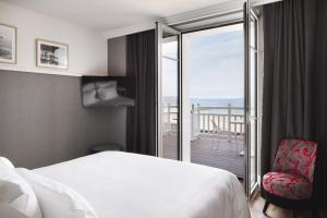 a hotel room with a bed and a balcony at Grand Hôtel Perros-Guirec in Perros-Guirec