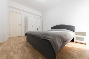 um quarto com uma cama grande e piso em madeira em Ines em Bucareste