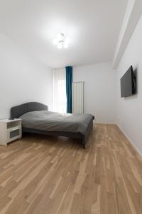 1 dormitorio con 1 cama y suelo de madera en Ines, en Bucarest