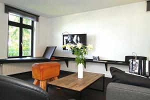 a living room with a vase of flowers on a table at Villa Schering App 4 Black White in Heringsdorf