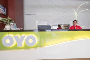 a woman is standing behind a company counter at Collection O 91714 Hotel Alden in Makassar