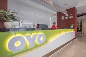 a woman standing behind aoops counter in a restaurant at Collection O 91714 Hotel Alden in Makassar