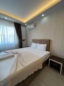 a bedroom with a large bed and a window at Grand Black Hotel in Mersin