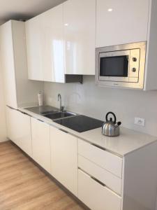 a white kitchen with a sink and a microwave at MONNALISA VENICE APARTMENT in Venice