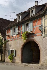 ein Gebäude mit einer Garage und einem Gebäude mit einer Tür in der Unterkunft ANNO 1698 Gîtes et Chambres d'Hôtes in Beblenheim