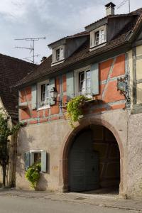 a building with a garage and a building with a door at ANNO 1698 Gîtes et Chambres d'Hôtes in Beblenheim