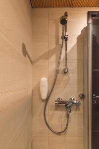 a shower in a bathroom with a shower head at Skihouse Apartment in Levi