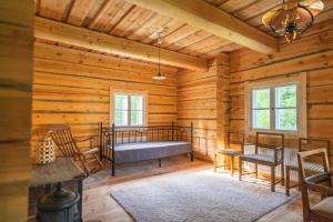 a bedroom in a log cabin with a bed and chairs at Unique loghouse and wood heated sauna in Ii in Ii