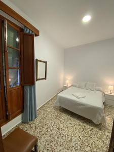 a bedroom with a bed and a window at Casa Pepe La Rosa in Tolox