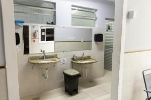 a bathroom with two sinks and a trash can at Hostel Diniz in Vitória