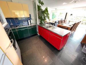 a kitchen with a red counter and a dining room at Vakantiehuis met eigen aanlegsteiger in Kortgene +13 photos