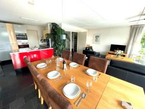 a dining room with a wooden table and chairs at Vakantiehuis met eigen aanlegsteiger in Kortgene
