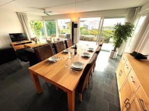 a wooden table with chairs and a dining room at Vakantiehuis met eigen aanlegsteiger in Kortgene