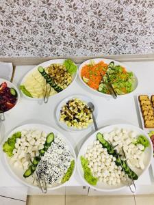 stół z kilkoma talerzami żywności w obiekcie Grand Black Hotel w mieście Mersin
