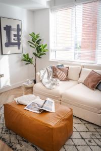 uma sala de estar com um sofá branco e um repousa-pés em Royal House Luxury Apartments - Chester em Chester