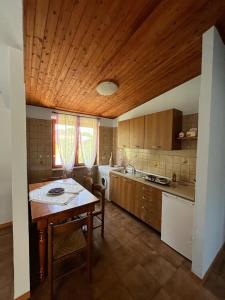 a kitchen with a table and a wooden ceiling at B&B Roccamonfina in Roccamonfina