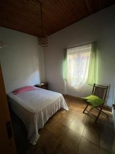 a bedroom with a bed and a chair and a window at B&B Roccamonfina in Roccamonfina