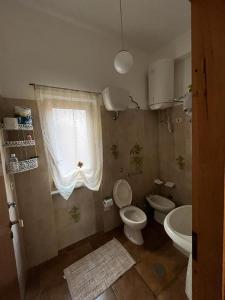 a bathroom with a toilet and a sink and a window at B&B Roccamonfina in Roccamonfina