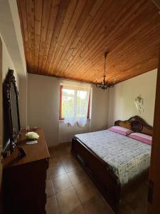 1 dormitorio con cama y techo de madera en B&B Roccamonfina, en Roccamonfina