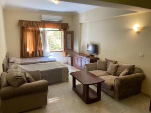 a living room with a bed and a couch and a table at Bahga Palace 3 Residential Apartments in Hurghada