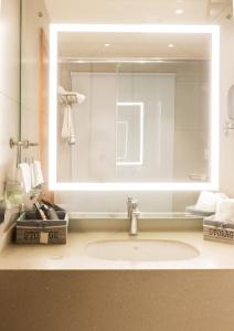 a bathroom with a sink and a large mirror at Clarks Inn Express Ludhiana in Ludhiana