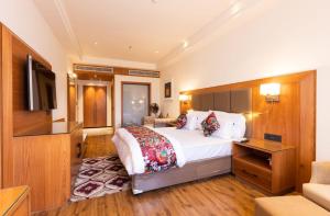 a hotel room with a bed and a television at Clarks Inn Express Ludhiana in Ludhiana