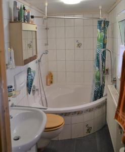 a bathroom with a tub and a toilet and a sink at Auszeit by Annette in Hohenwarth