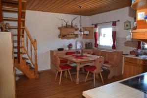 a kitchen with a table and chairs and a staircase at Auszeit by Annette in Hohenwarth