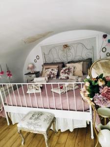 ein Schlafzimmer mit einem weißen Bett mit einer rosa Tagesdecke in der Unterkunft La Règia in Palagianello