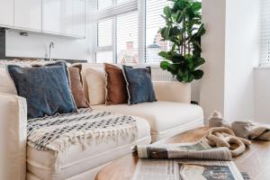 a living room with a white couch and blue pillows at Royal House Stylish Apartments - Chester in Chester +74 photos
