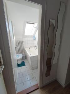 a bathroom with a tub and a toilet and a sink at Ferienwohnung kleine Möwe mit E-Bike Verleih in Wilhelmshaven