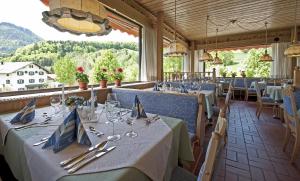 a dining room with tables and a view of the mountains at Landhotel Maiergschwendt inkl Chiemgaukarte in Ruhpolding