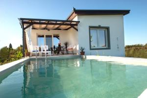 a swimming pool in front of a house at Olympus Horizon Pool Villa in Paralia Katerinis