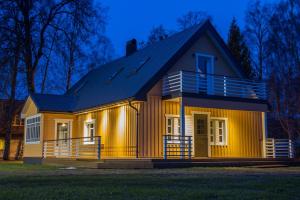 uma pequena casa amarela com um telhado escuro em Kalurikodu Holiday Home em Kärdla