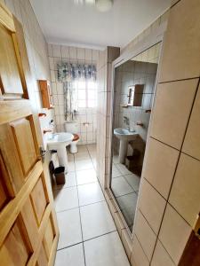 ein Badezimmer mit einem WC, einem Waschbecken und einem Spiegel in der Unterkunft Resthaven Guesthouse in Matatiele