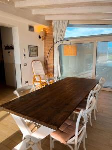 una mesa de madera y sillas en la sala de estar. en Cottage indipendente con piscina privata, en Masi San Giacomo