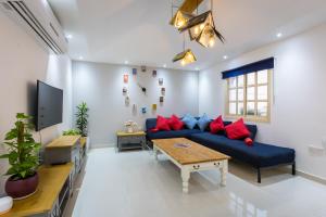 a living room with a blue couch and red pillows at My Way in Ras al Khaimah