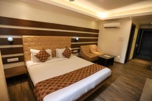 Habitación de hotel con cama y silla en Hotel Coal Capital, en Dhanbād
