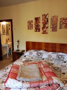 een slaapkamer met een bed met een quilt bij Accogliente casa in pietra in borgo medievale in Serra Pistoiese